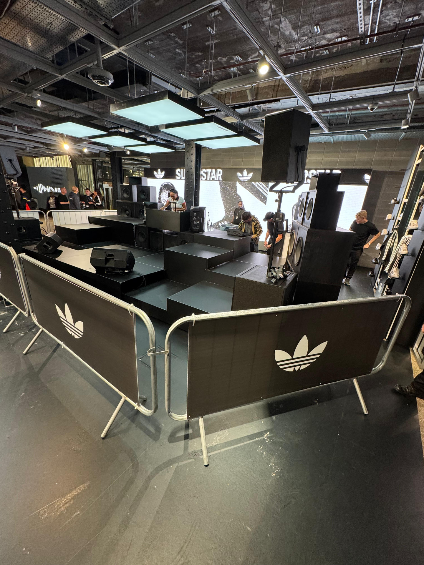 Multi-level stage build with line array speakers and DJ booth in store