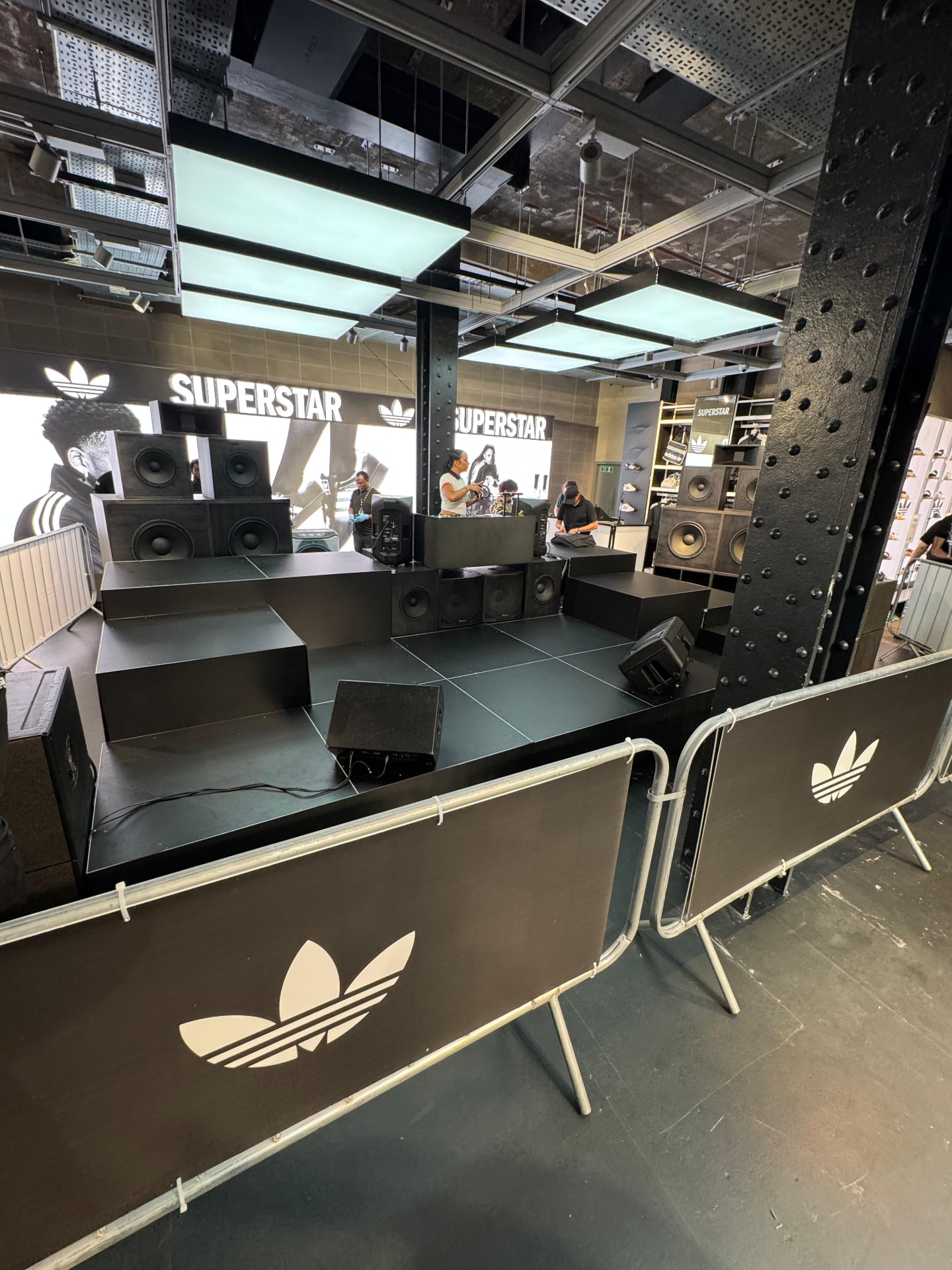 Modular black stage with stacked speaker system and branded crowd barriers